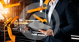 XAI Engineer use advanced robotic software to control industry robot arm in factory