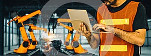 XAI Engineer use advanced robotic software to control industry robot arm in factory