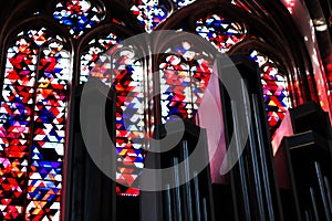 View on organ pipes against colorful bright mosaic windows inside church St. Viktor Dom