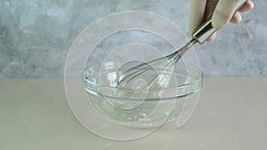Xanthan gum powder is mixed with water and whipped with whisk in glass bowl. Food additive E415, natural gluten-free thickener