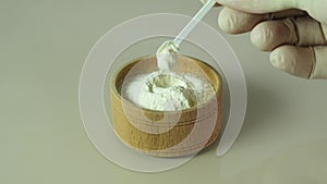 Xanthan Gum Powder in wooden bowl with measuring spoon. Food additive E415, used in food industry