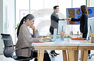 XAsian young professional successful businesswoman employee colleagues in formal suit sitting, typing report with laptop while