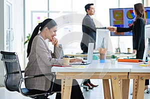 XAsian young professional successful businesswoman employee colleagues in formal suit sitting, typing report with laptop while