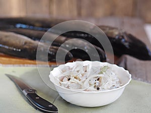 XE salad of freshly salted pike river fish on the background of pike river fish on a cutting board in the kitchen. We chop the