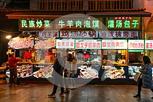 Xian, China - December 29, 2019: Street food night market with crowed pedestrain street in the Muslim Quarter at Xian China