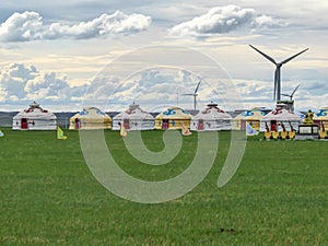 Xilinhot - Yellow and white traditional yurts located on a pasture in Xilinhot in Inner Mongolia. Endless grassland. Blue sky