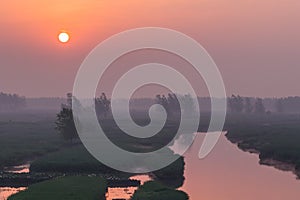 XINGHUA, CHINA: Canal in rapeseed field at morning