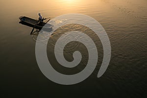 XINGHUA,Paddle boat along canal in rapeseed field at morning