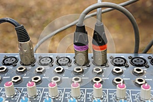 XLR connector for microphone cables are connected to sound music mixer control panel.