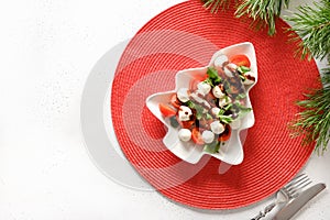 Xmas Caprese salad served in plate as Christmas tree for festive Xmas party. View from above