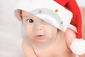 Xmas card with cute baby girl with santa hat on beige airy briht background with copy space