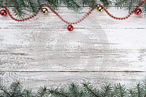 Xmas card. Old wooden Christmas background. Fir branches. Gold and red baubles. Red garlands