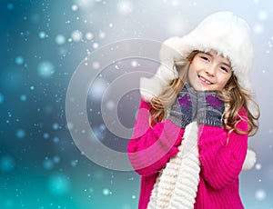 Xmas child girl winter clothes on snowy background.