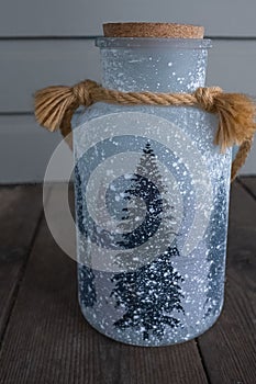 Xmas Concept - Snowy Christmas Tree painted on a Jar. Christmas tree decoration on a jar. Handmade glass jar