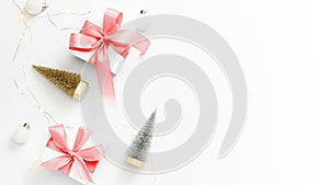 Xmas decoration. White gifts with red bow, balls, sparkling lights in Christmas decoration on white background for greeting card.
