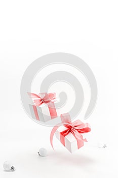 Xmas decoration. White gifts with red ribbon and New Year balls in Christmas decoration on white background for greeting card.