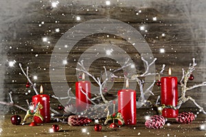 Xmas decoration on wooden rustic background: four red burning ad