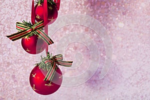 Xmas decorations - red balls on blurred pink christmas background with lights bokeh. Copy space