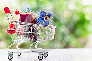 Xmas decorative items in mini shopping cart or trolley against b