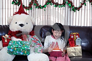 Xmas Festive asian little girl surprise and open a gift box at home