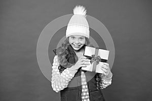 Xmas gift idea. Winter holidays. Kid girl winter outfit hold wrapped gift box. Meanie grimace. Christmas gifts