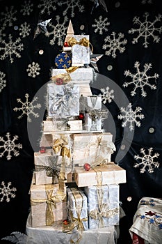 Xmas gifts are Packed in boxes in the form of a large Christmas tree on a dark background with snowflakes