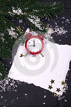 Xmas greeting card. Christmas background with snow fir tree and alarm clock. View from above with space for your