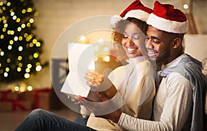 Xmas magic. Cute couple opening Christmas gift box