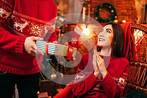 Xmas, male person makes gift to beautiful woman