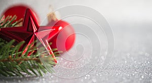 Xmas tree and red ornaments on glitter holiday background.