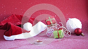 Xmas, winter, new year concept - red Christmas background cover with white snow Santa hat with burning candle and toy