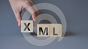 XML - Extensible Markup Language. Wooden cubes with word XML. Businessman hand. Beautiful grey background. Business and Extensible photo