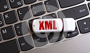 XML - the word on a white flash drive, lying on a black laptop keyboard photo