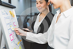 XMobile Application Designers are development on smartphone and pink paper note on hand.