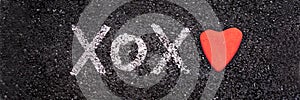 Xoxo written on the ground with a heart shapes stone Valentines day web banner