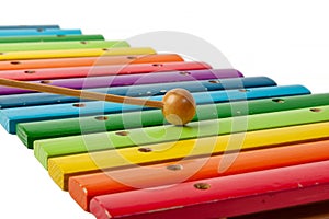 Xylophone musical instrument with wooden bars painted in rainbow and maleta colors on a white isolated background photo