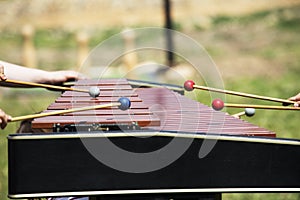 Xylophone with playing hands. Red marimba xylophone. Music percussion instrument.