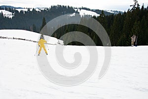 Yablunytsya, Ukraine February 2, 2019: woman in a yellow suit goes skiing, tourists of Ukraine in the village of Yablunytsya