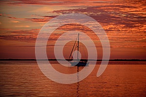 Yach on water. Boat on ocean at sunset. Sailboats with sails. Sea traveling.