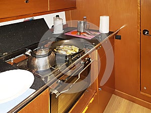 Yacht Bavaria caribian cruiser. Maritimes kitchen. Kabuz. Frying fish in the galley of a sailing yacht. A healthy diet and a photo