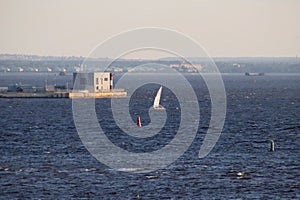 The yacht crosses the Gulf of Finland with a building on the pier