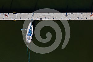 Yacht in the dock from above on a dark water background