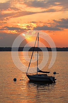 Yacht drifting on the lake during beautiful summer sunset