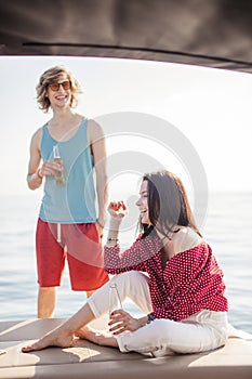 Yacht drinking beers while talking Group of friends having party on sailing boat