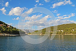 A yacht entering the bay by the town. Pucisca is small town on Island of Brac, Croatia