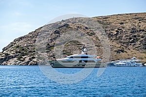 Yacht, luxury motorboat moored at a secluded beach, Kythnos island Greece. Summer vacation