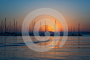 Yacht marina on Balaton lake at sunset, scenic view of the boats, sun, sky and water, outdoor travel background, Siofok, Hungary