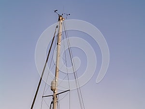 Yacht mast with rigging, stays and windex on top photo
