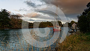 Yacht moored on the Catlins river at sunset, Owaka, southland, south island, Aotearoa / New Zealand