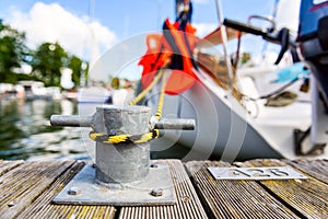 Yacht moored with a line tied around a fixing on the pier